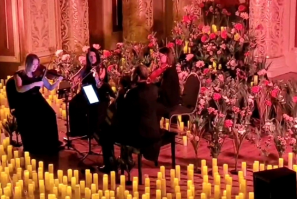 String quartet performing Coldplay music by candlelight at an atmospheric concert for women’s social group event in St Georges Hall, Liverpool.