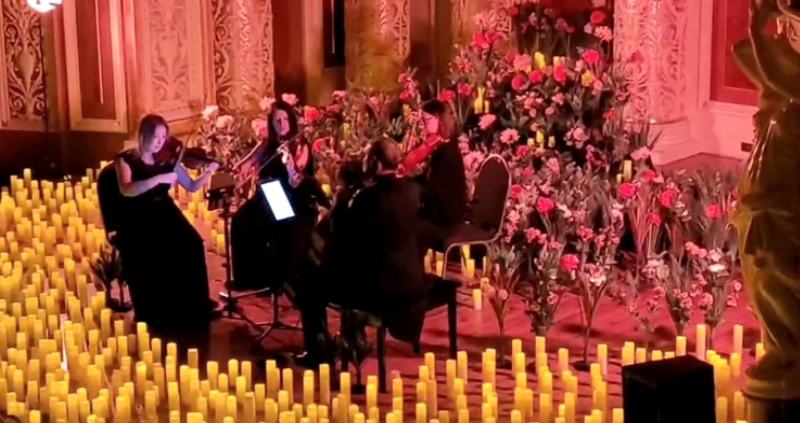String quartet performing Coldplay music by candlelight at an atmospheric concert for women’s social group event in St Georges Hall, Liverpool.