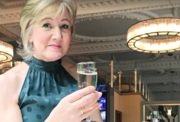 Culture Calendar host Catherine smiling and raising a glass at a women’s social event in Merseyside.