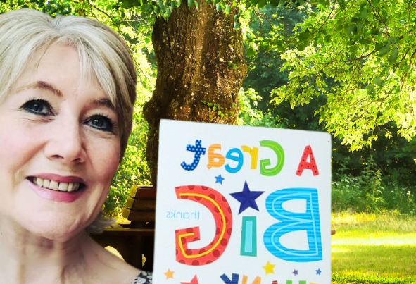 Catherine, founder of Culture Calendar Women’s Social Group in Merseyside and West Lancashire, smiling and holding a thank you card after gifting tulips to a member as a gesture of friendship and appreciation.