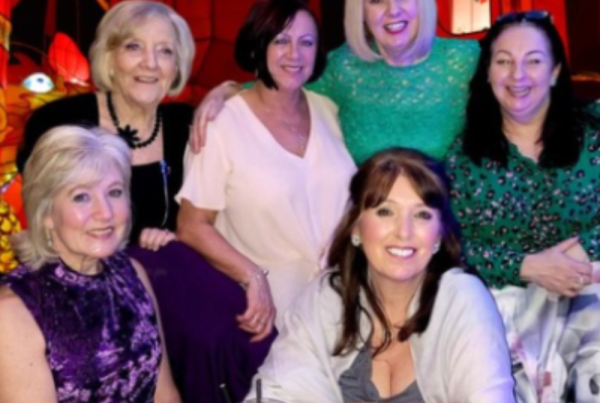 Group of smiling Culture Calendar women enjoying a Chinese New Year banquet celebration in Ormskirk, surrounded by festive decor and laughter.